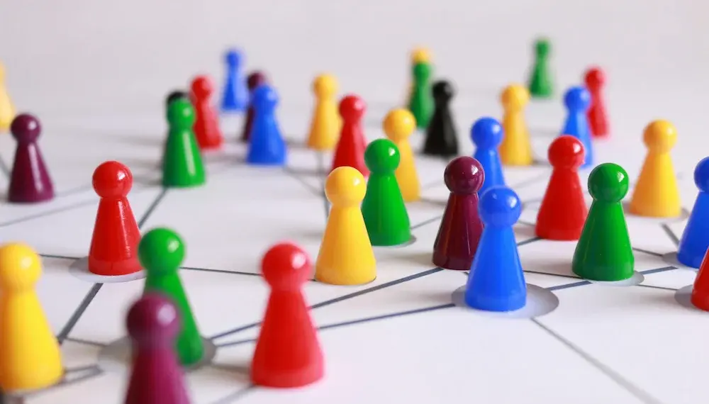 Das Bild zeigt Halma-Figuren auf einem Netzwerk-Linienmuster